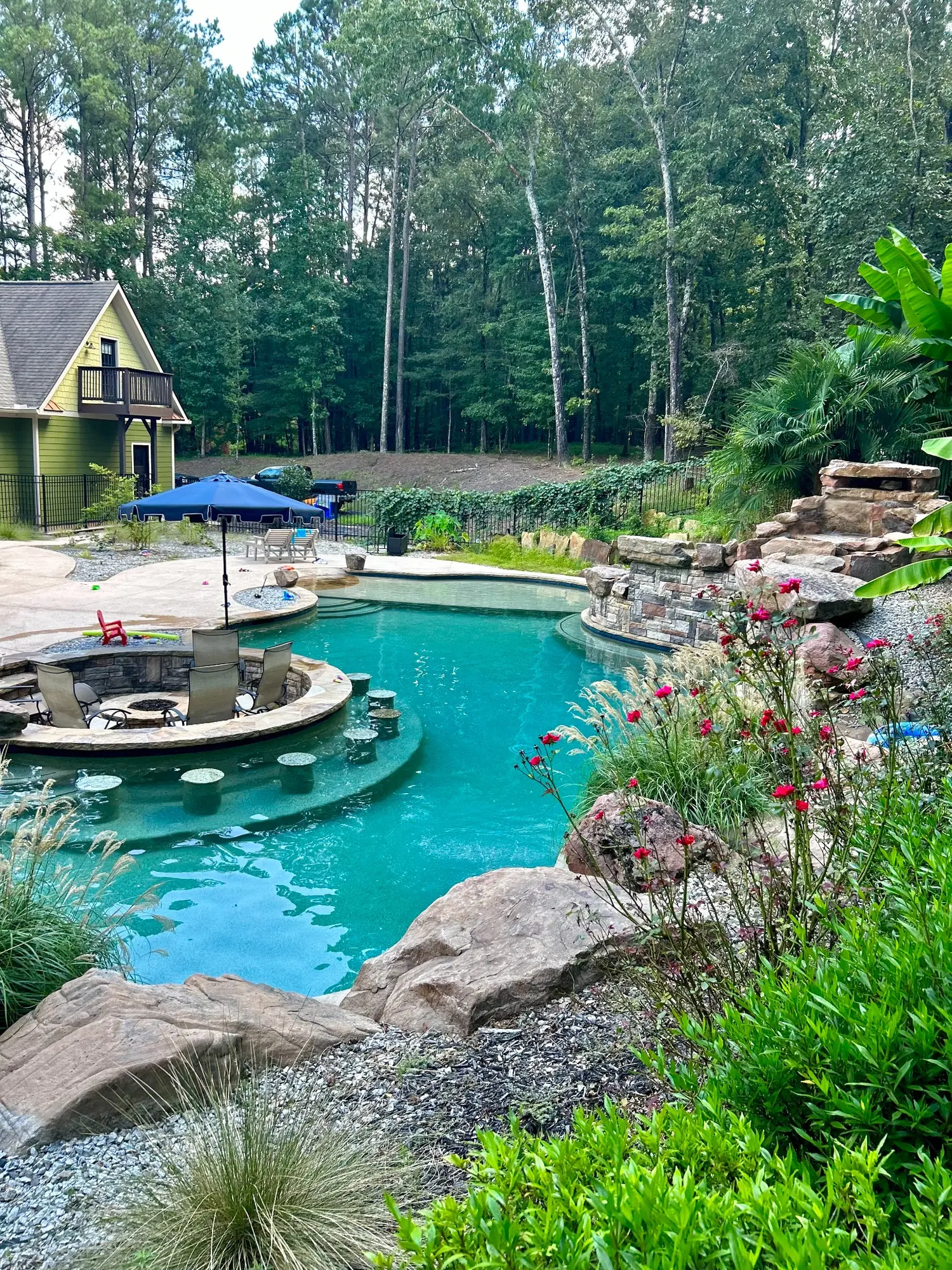 Clear resort-style pool with rockwork and a sunken seating area